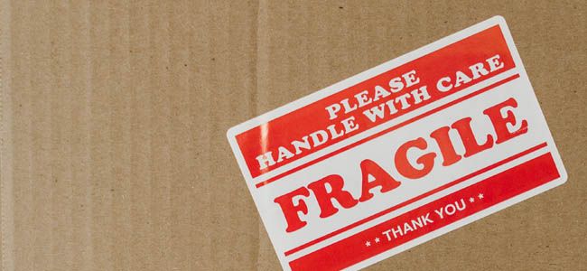 Umzugskarton mit Aufkleber auf dem steht: Please handle with care, Fragil